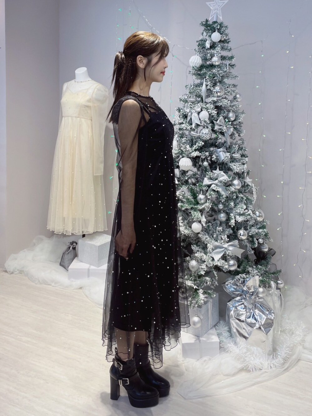 ブラック系のワンピース、ブラック系のブーツを着用したレディースの秋コーディネートの6枚目の写真