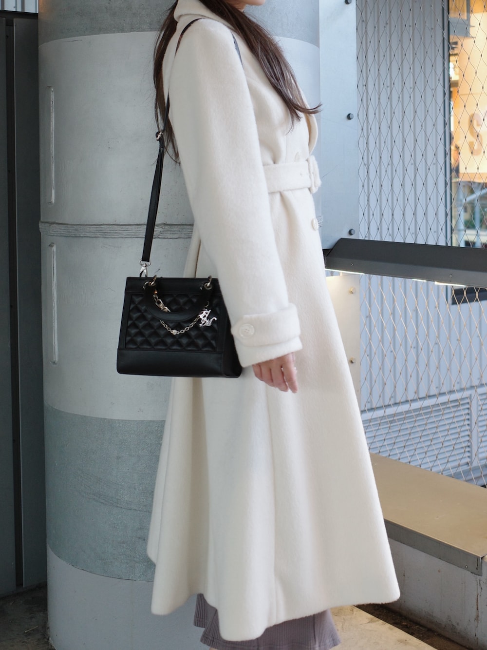 ホワイト系のその他アウター、ブラック系のハンドバッグを着用したレディースの冬コーディネートの4枚目の写真