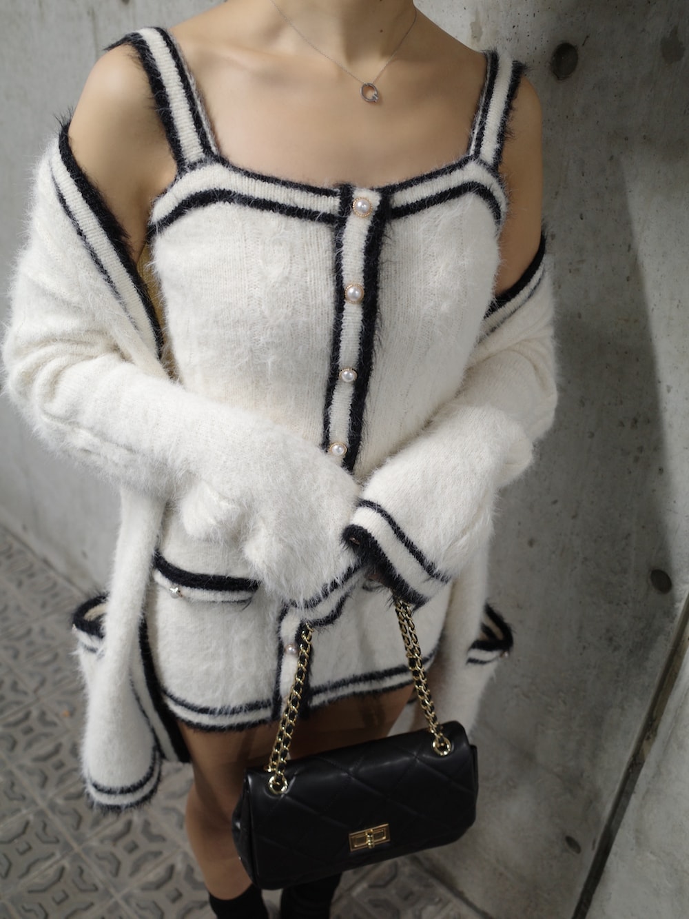 ホワイト系のワンピース、ブラック系のブーツ、ブラック系のハンドバッグを着用したレディースの秋コーディネートの4枚目の写真