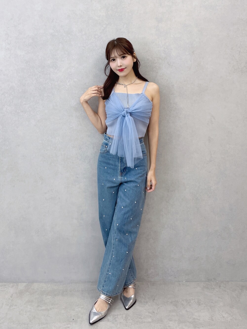 ブルー系のキャミソール、ブルー系のデニムパンツ、シルバー系のネックレスを着用したレディースの夏コーディネートの4枚目の写真