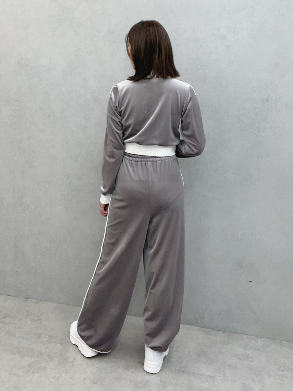 グレー系のブルゾン、グレー系のその他パンツ、ホワイト系のスニーカーを着用したレディースの秋コーディネートの4枚目の写真