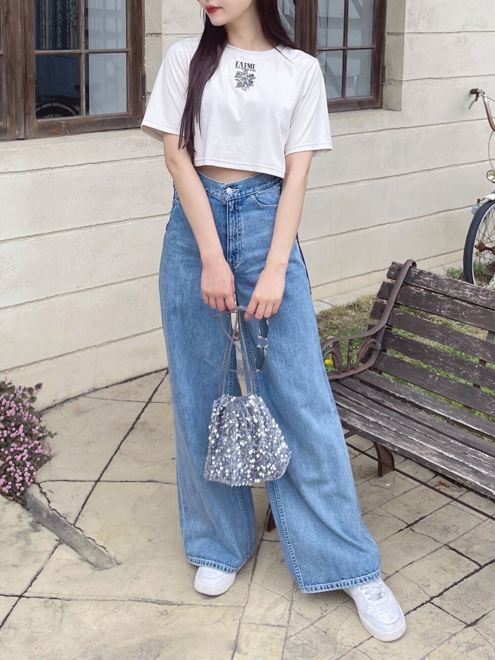 ブルー系のデニムパンツ、シルバー系のハンドバッグ、ホワイト系のTシャツ/カットソーを着用したレディースの春コーディネートの4枚目の写真