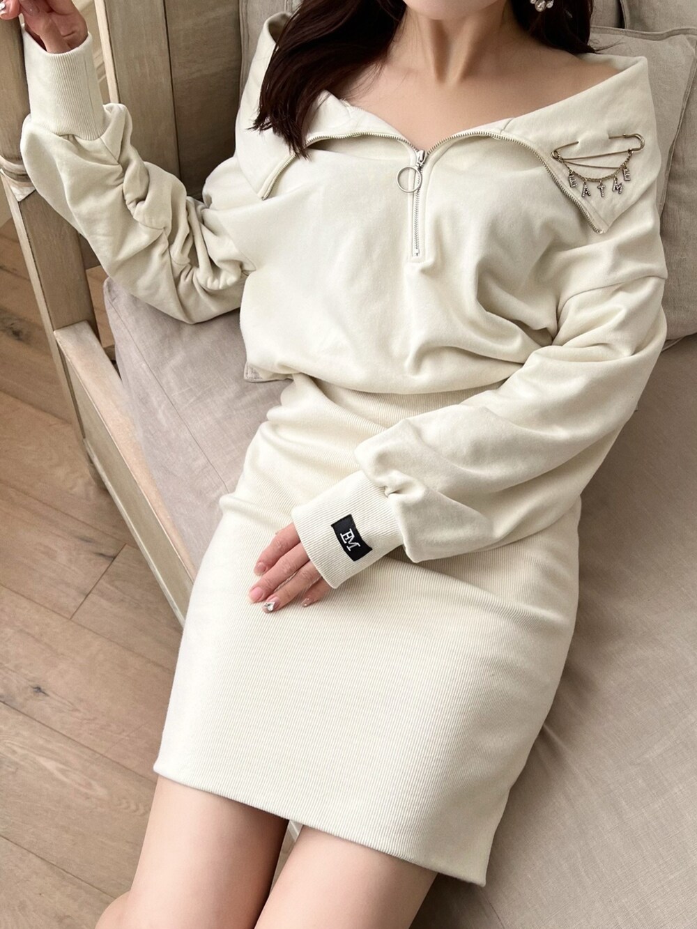 ホワイト系のワンピース、ブラック系のブーツ、シルバー系のブローチ/コサージュを着用したレディースの秋コーディネートの6枚目の写真