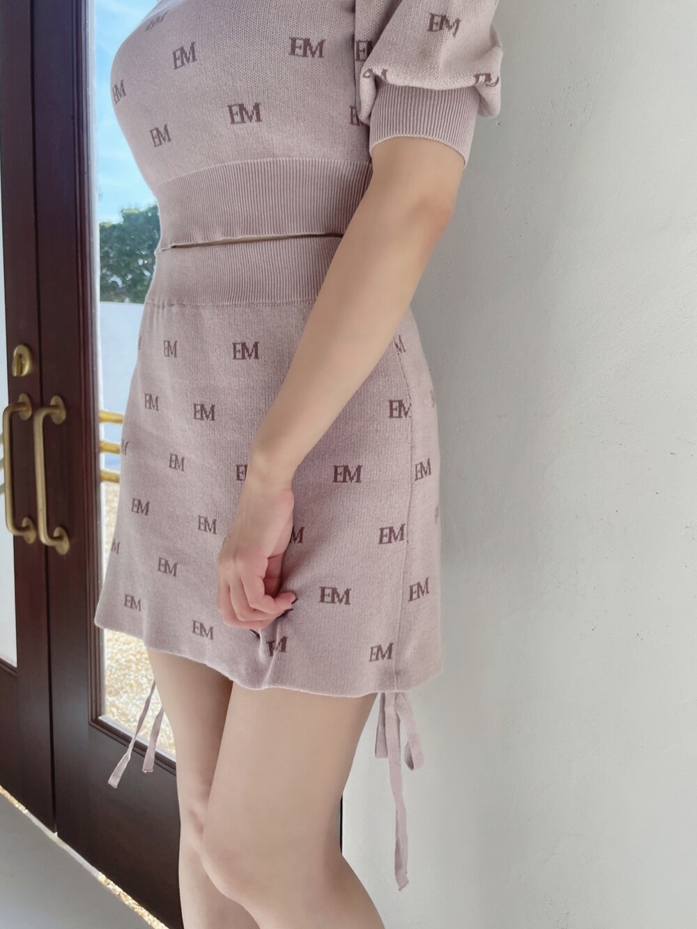 ピンク系のニット/セーター、ピンク系のスカート、ブラック系のパンプスを着用したレディースの冬コーディネートの9枚目の写真