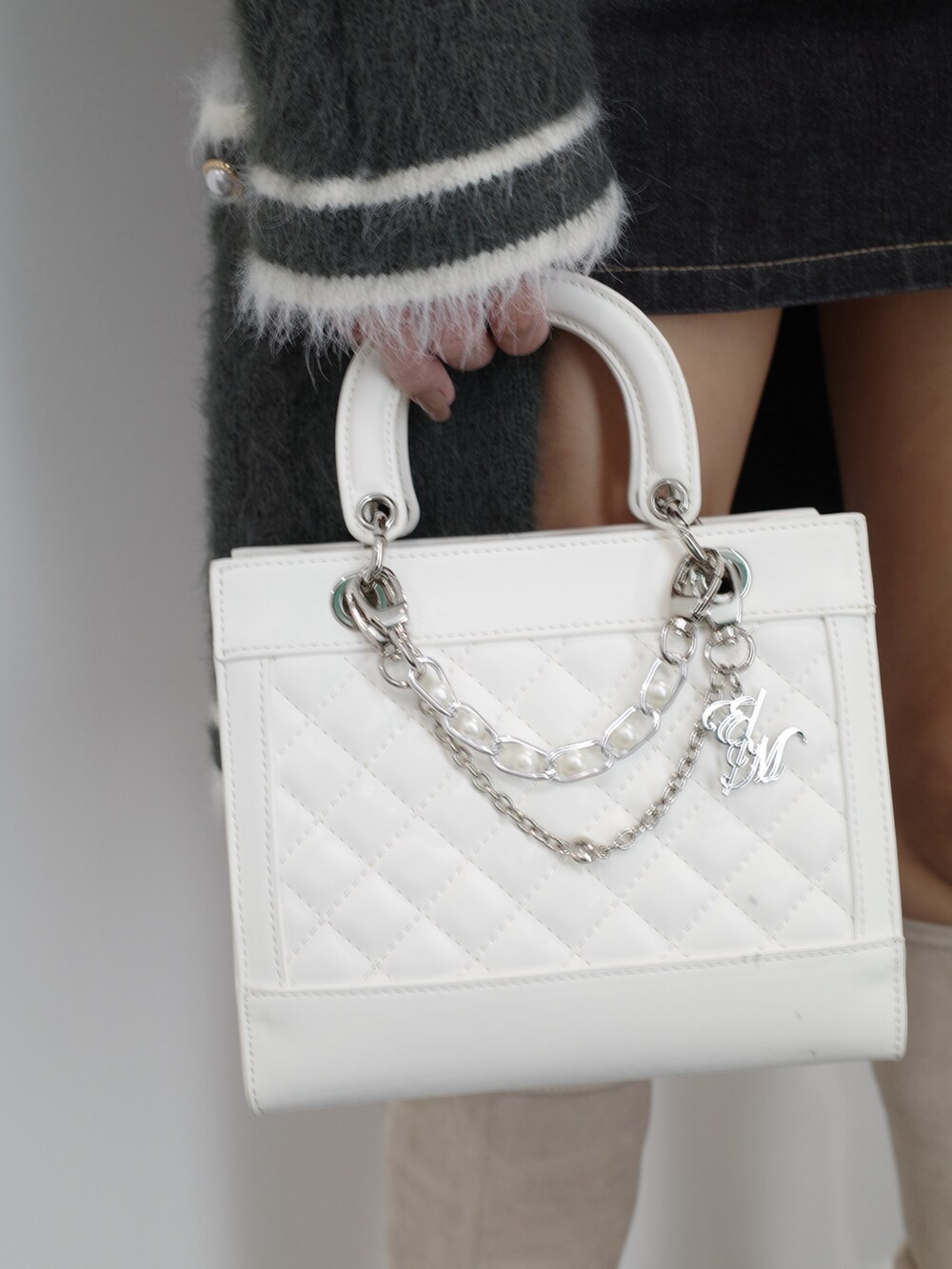 ブラック系のニット/セーター、グレー系のワンピース、ブルー系のデニムスカートを着用したレディースの秋コーディネートの10枚目の写真