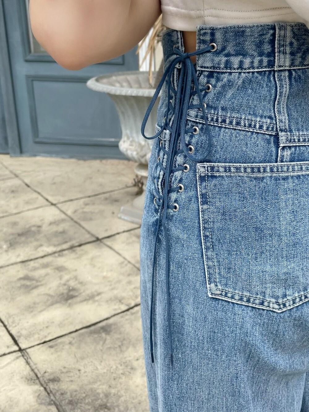 ブルー系のデニムパンツ、シルバー系のハンドバッグ、ホワイト系のTシャツ/カットソーを着用したレディースの春コーディネートの9枚目の写真