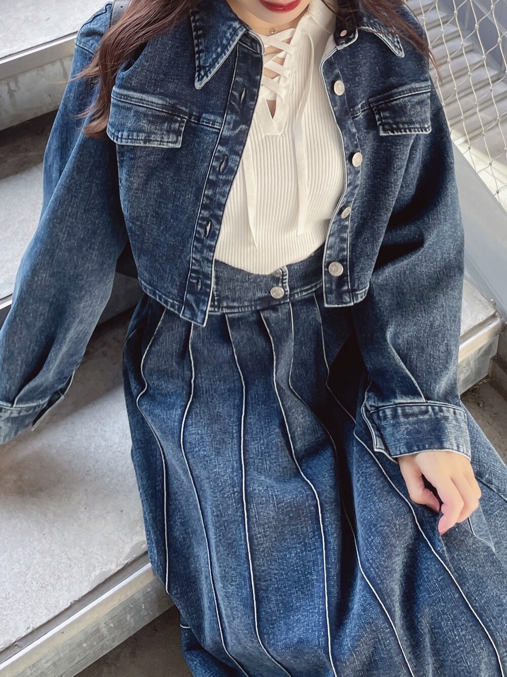 ブルー系のデニムスカート、ホワイト系のニット/セーター、ブルー系のデニムジャケットを着用したレディースの春コーディネートの4枚目の写真