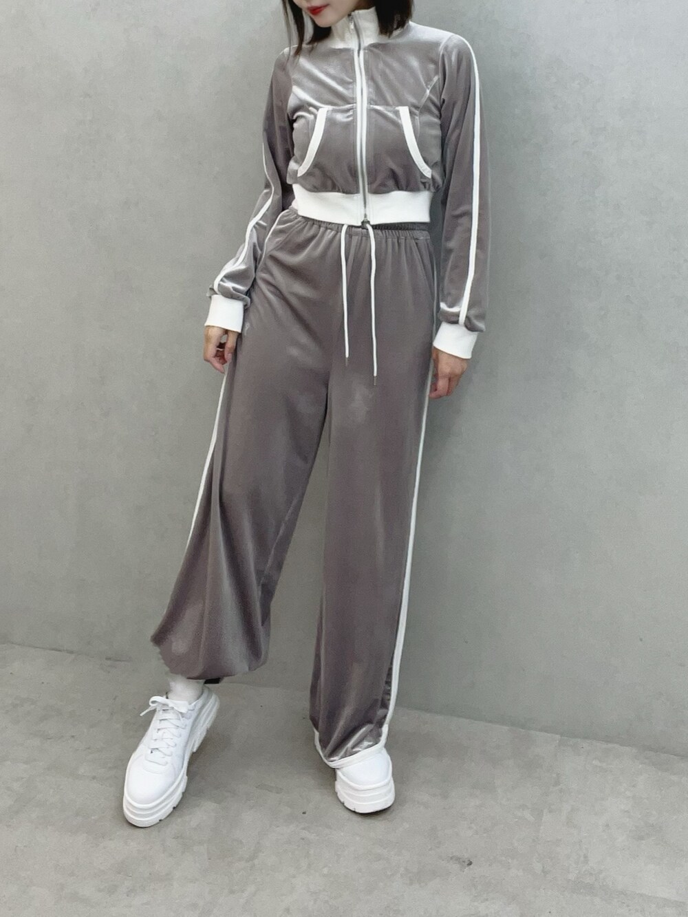 グレー系のブルゾン、グレー系のその他パンツ、ホワイト系のスニーカーを着用したレディースの秋コーディネートの2枚目の写真