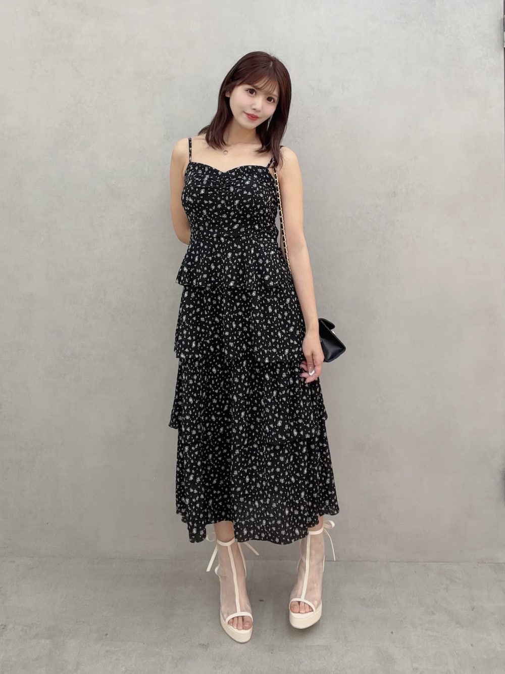 ホワイト系のサンダル、ブラック系のワンピース、ブラック系のハンドバッグを着用したレディースの冬コーディネートの2枚目の写真