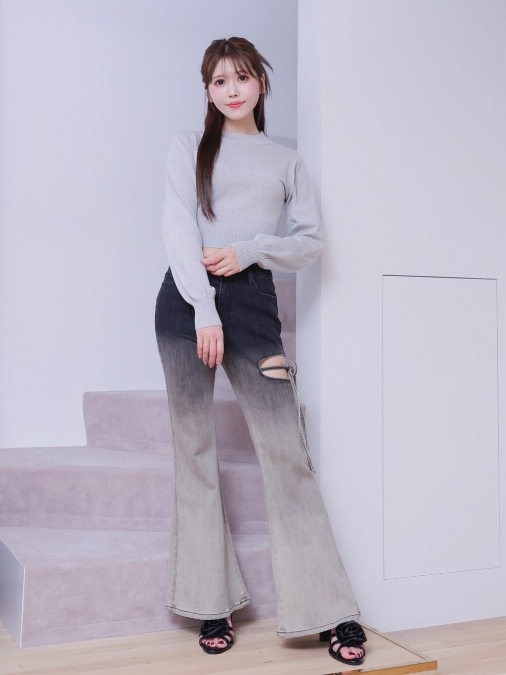 ブラック系のデニムパンツ、ブラック系のサンダル、グレー系のニット/セーターを着用したレディースの春コーディネートの5枚目の写真