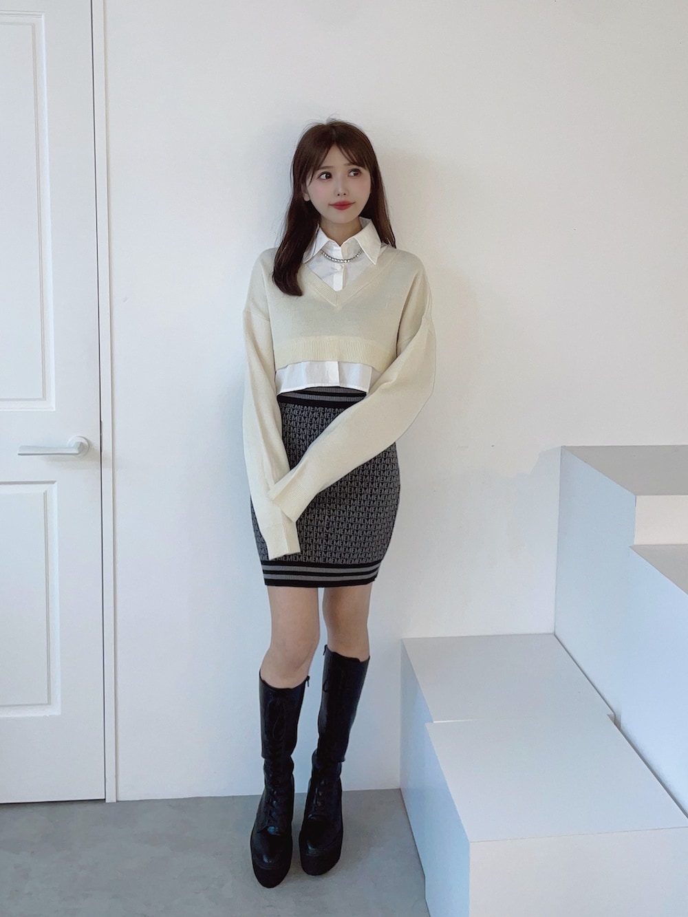 ホワイト系のシャツ/ブラウス、ブラック系のスカート、ブラック系のブーツを着用したレディースの秋コーディネートの6枚目の写真