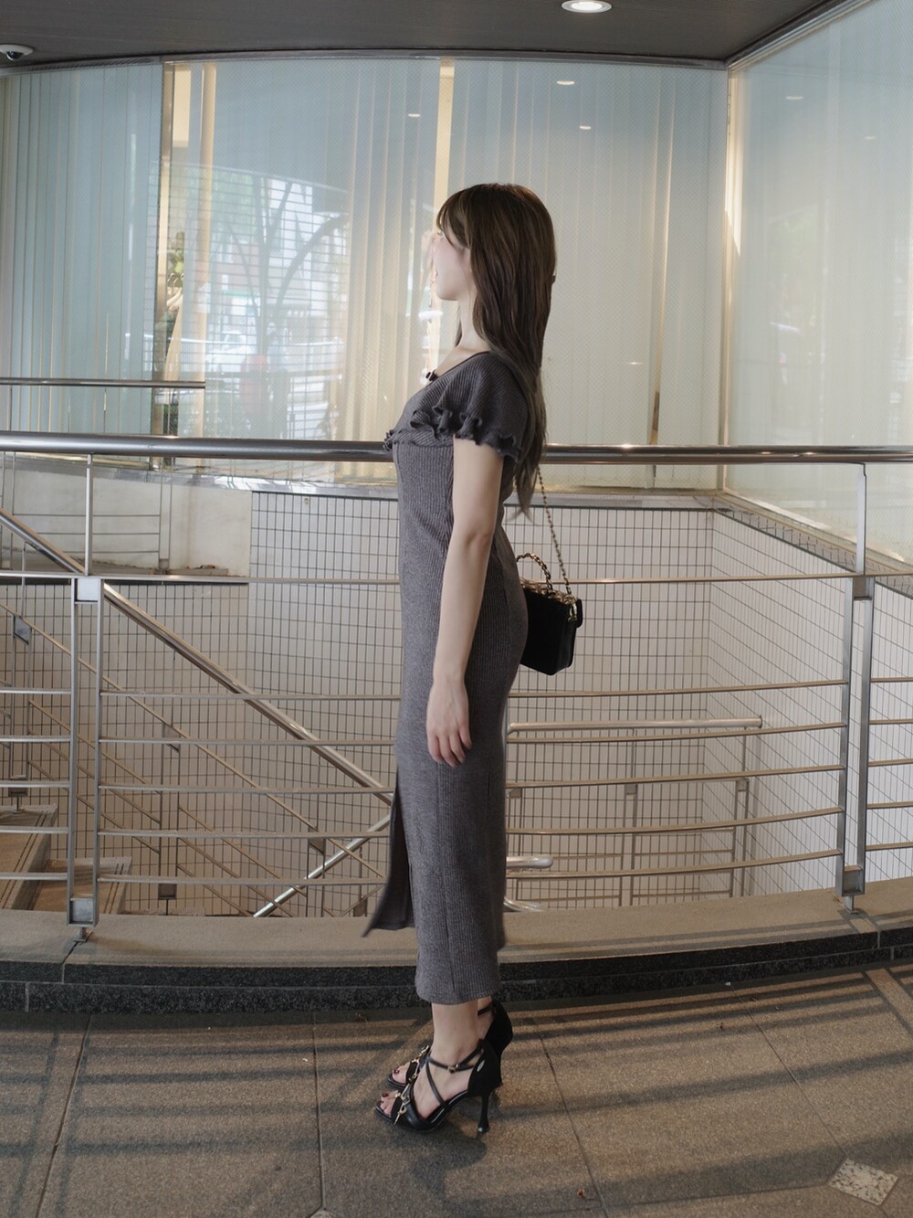 グレー系のワンピース、ブラック系のサンダル、ブラック系のショルダーバッグを着用したレディースの夏コーディネートの5枚目の写真