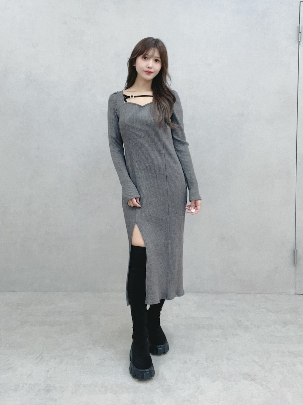 グレー系のワンピース、ブラック系のブーツを着用したレディースの冬コーディネートの2枚目の写真