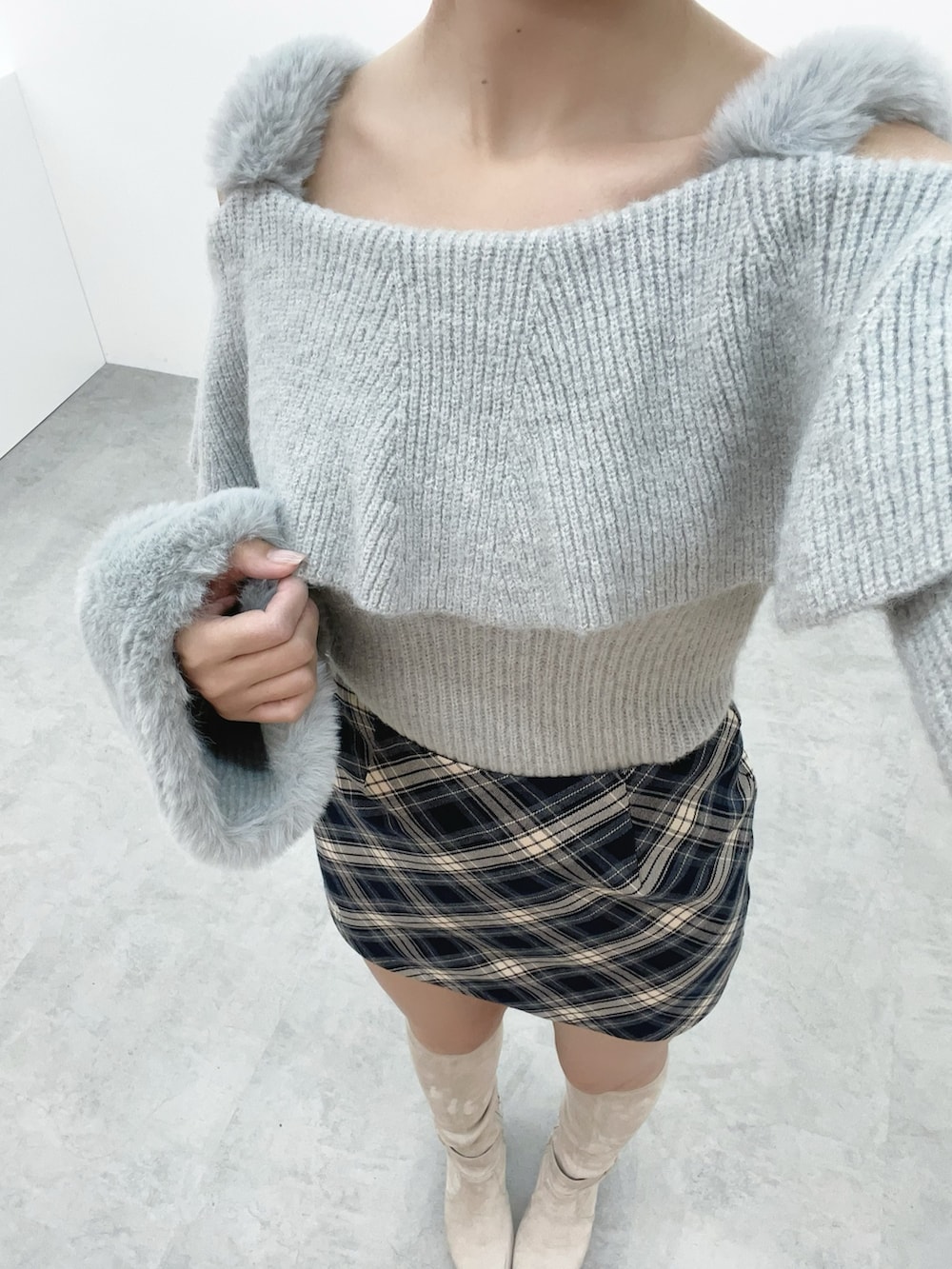 グレー系のニット/セーター、ホワイト系のブーツ、ブルー系のスカートを着用したレディースの秋コーディネートの6枚目の写真