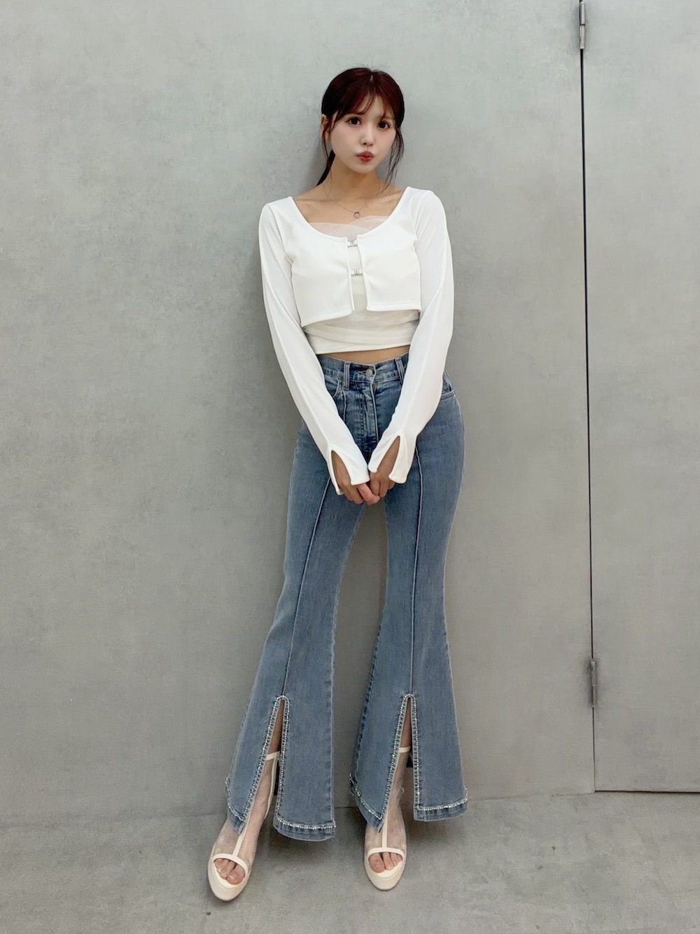 ブルー系のデニムパンツ、ホワイト系のTシャツ/カットソー、ホワイト系のサンダルを着用したレディースの冬コーディネートの3枚目の写真