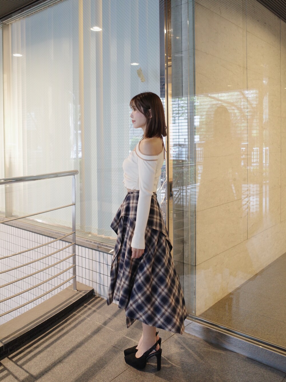 ホワイト系のTシャツ/カットソー、ブルー系のスカート、ブラック系のショルダーバッグを着用したレディースの秋コーディネートの3枚目の写真