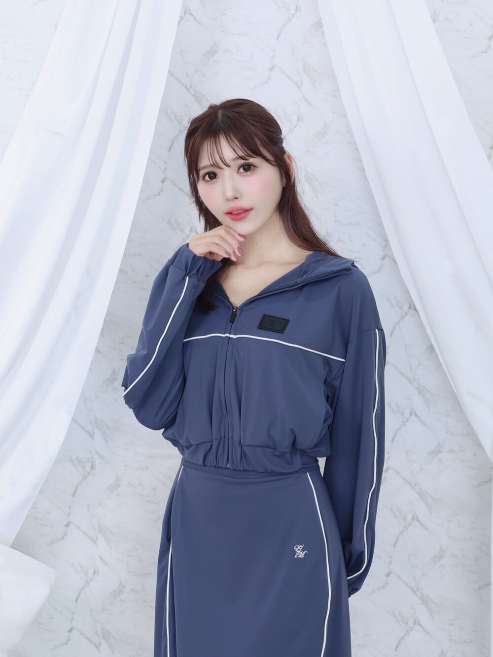 ブルー系のナイロンジャケット、ブルー系のスカートを着用したレディースの秋コーディネートの5枚目の写真