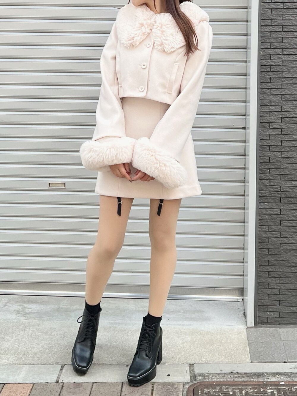 ホワイト系のセットアップ、ホワイト系のスカート、ブラック系のブーツを着用したレディースの秋コーディネートの4枚目の写真