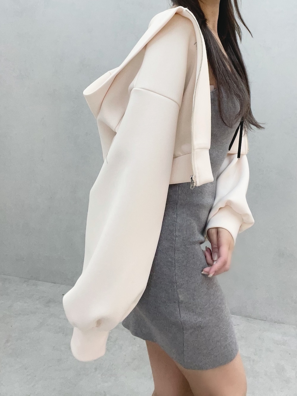 グレー系のワンピース、ホワイト系のパーカー、ホワイト系のブーツを着用したレディースの冬コーディネートの7枚目の写真