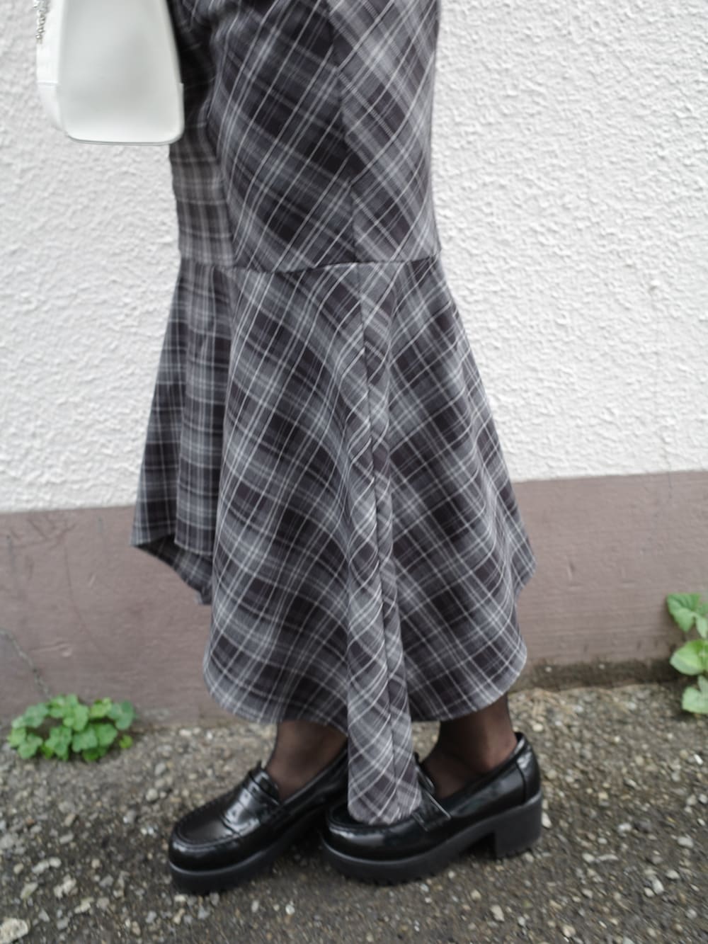 ブルー系のニット/セーター、ホワイト系のハンドバッグ、ブラック系のワンピースを着用したレディースの秋コーディネートの6枚目の写真