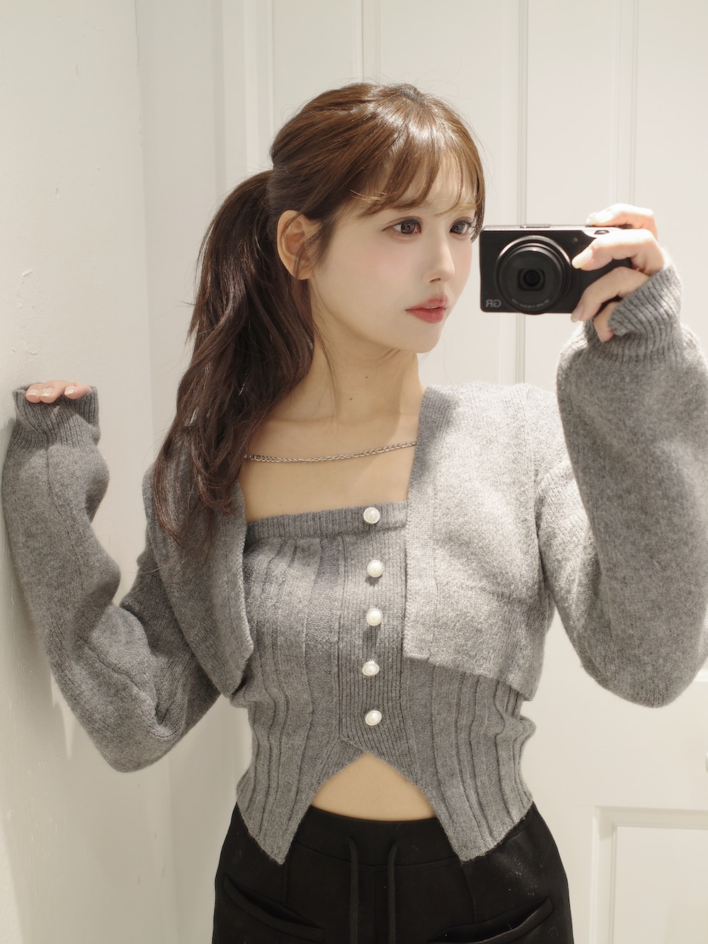 グレー系のニット/セーター、ブラック系のその他パンツ、ホワイト系のバックパック/リュックを着用したレディースの冬コーディネートの8枚目の写真