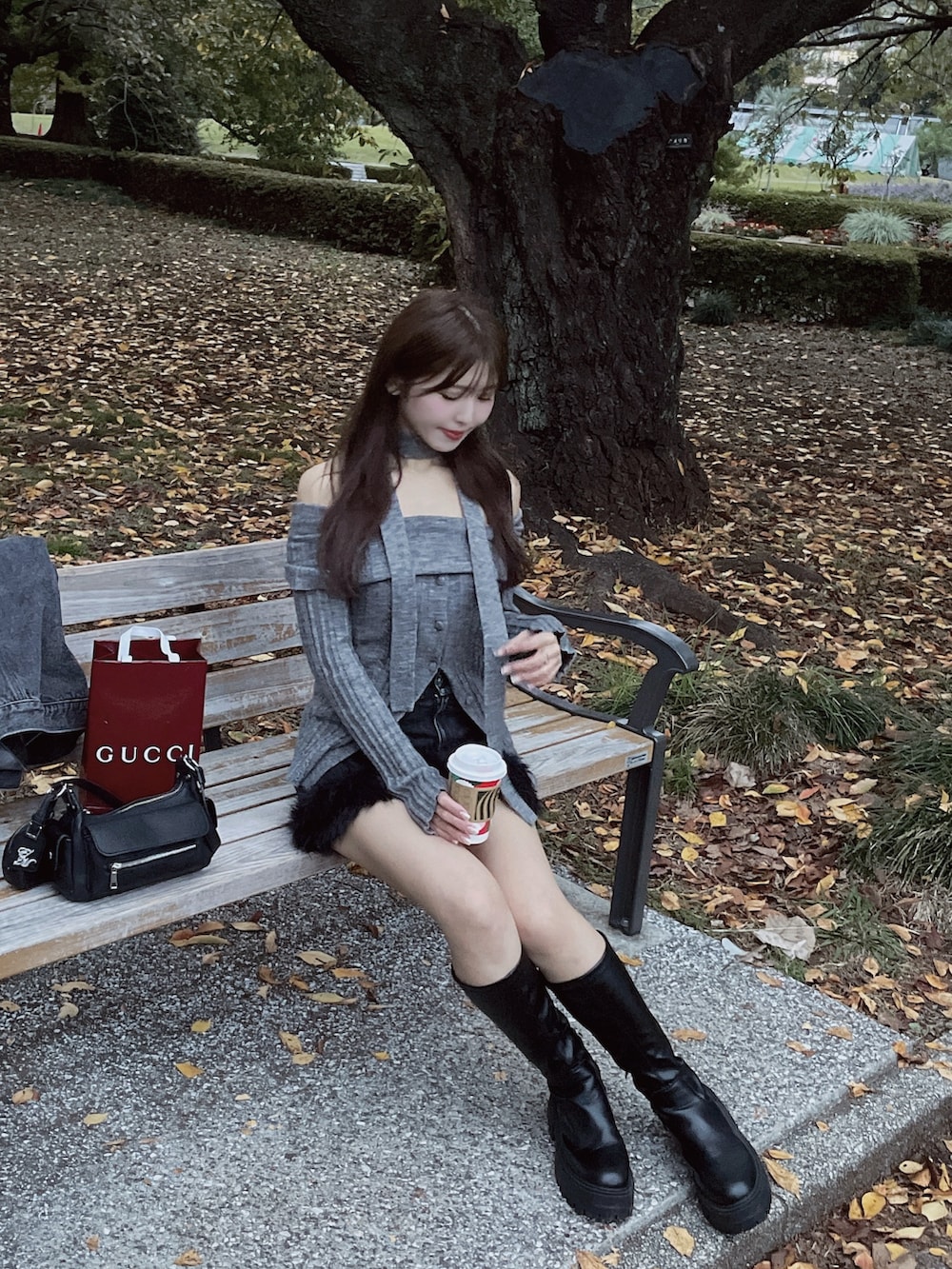 グレー系のニット/セーター、ブラック系のデニムスカートを着用したレディースの秋コーディネートの5枚目の写真