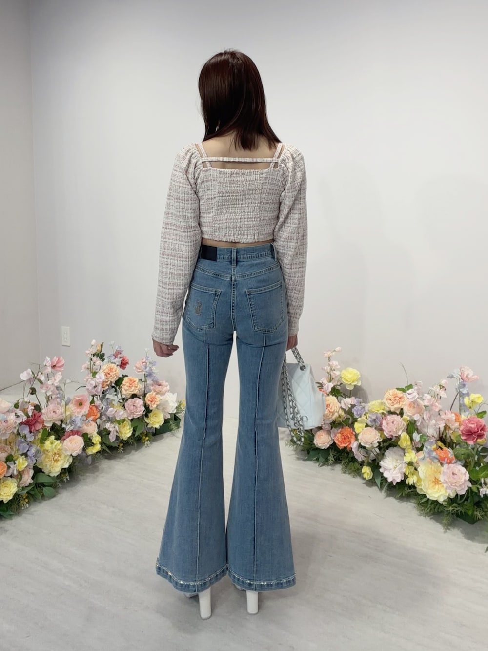 ブルー系のデニムパンツ、ホワイト系のバックパック/リュック、ホワイト系のサンダルを着用したレディースの冬コーディネートの4枚目の写真