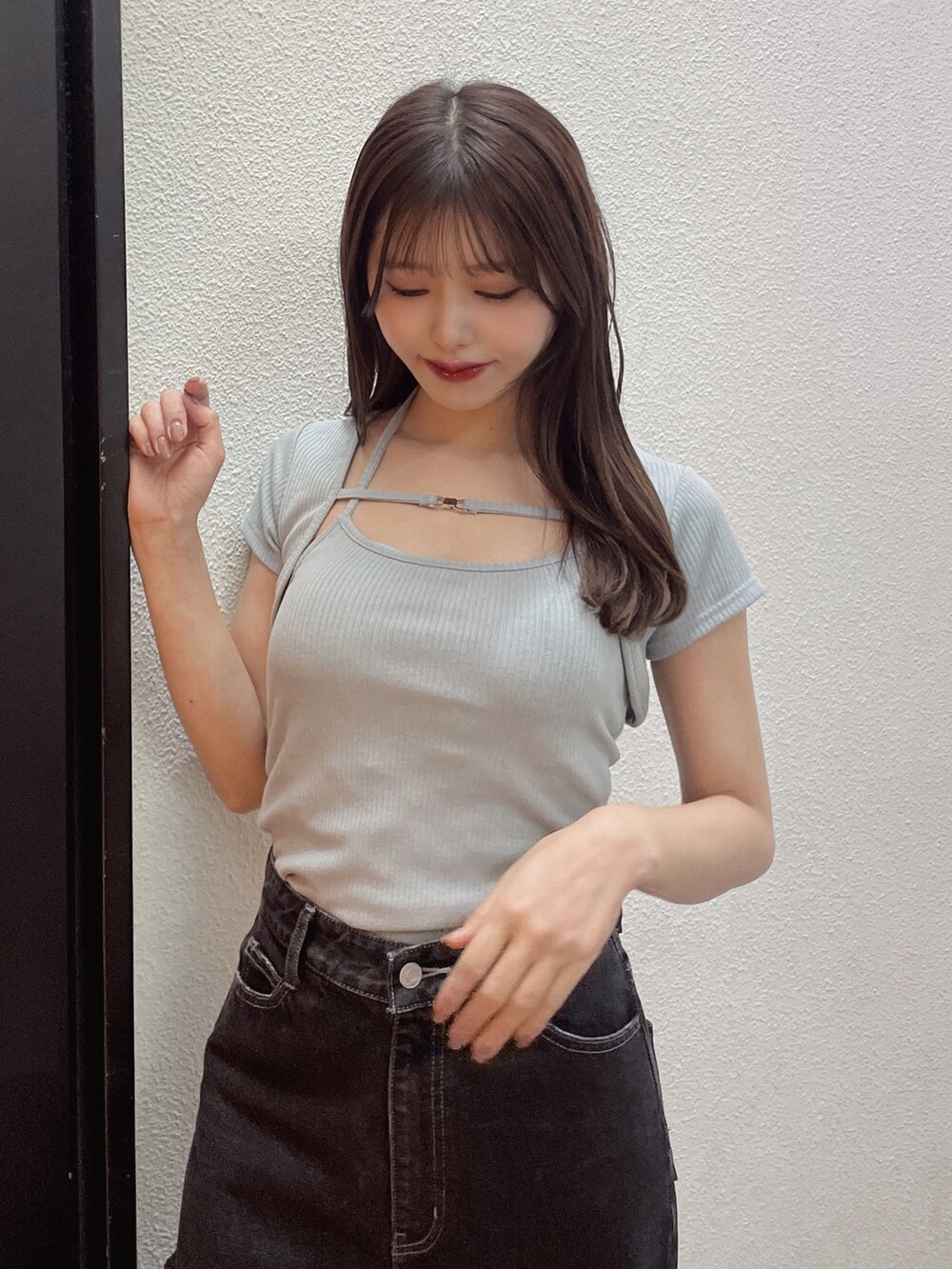 ブルー系のニット/セーター、ブラック系のデニムパンツ、ホワイト系のサンダルを着用したレディースの春コーディネートの5枚目の写真