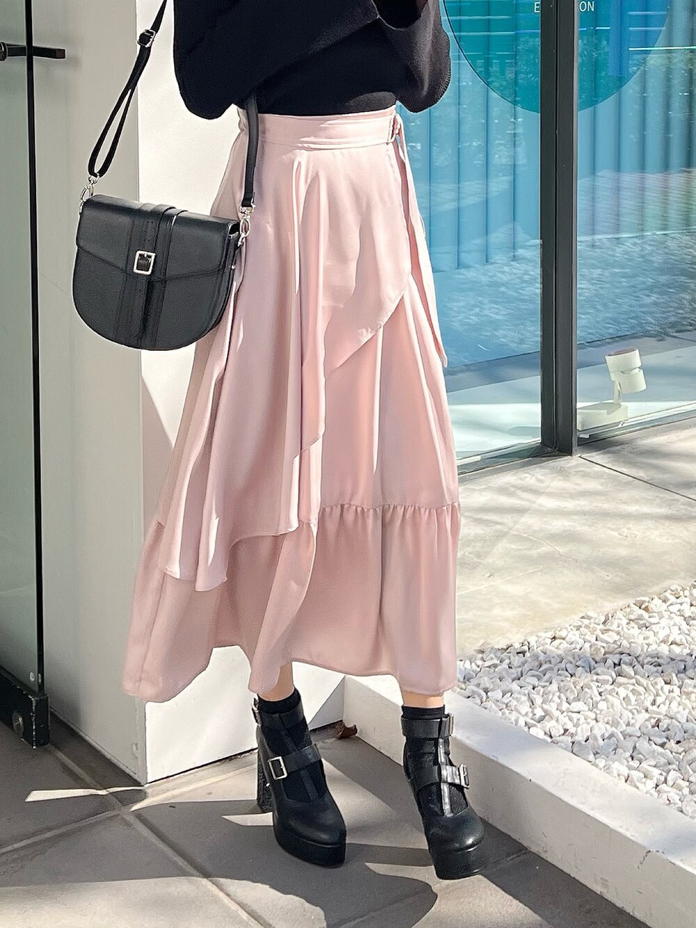 ブラック系のニット/セーター、ピンク系のスカート、ブラック系のショルダーバッグを着用したレディースの冬コーディネートの3枚目の写真