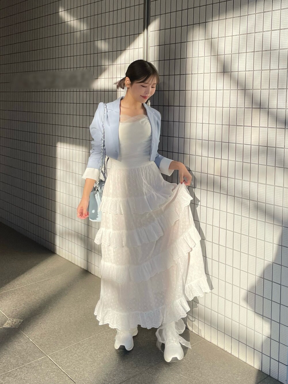 ホワイト系のスカート、ブルー系のハンドバッグ、ホワイト系のブーツを着用したレディースの春コーディネートの4枚目の写真