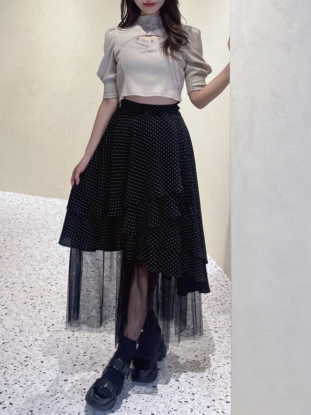 ベージュ系のニット/セーター、その他のスカート、ブラック系のサンダルを着用したレディースの冬コーディネートの2枚目の写真