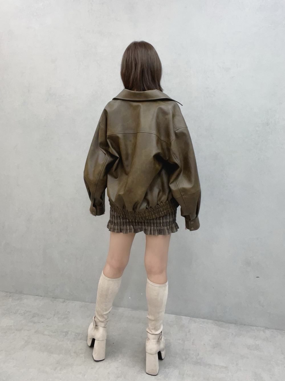 ブラウン系のワンピース、ブラウン系のブルゾン、ホワイト系のブーツを着用したレディースの秋コーディネートの4枚目の写真