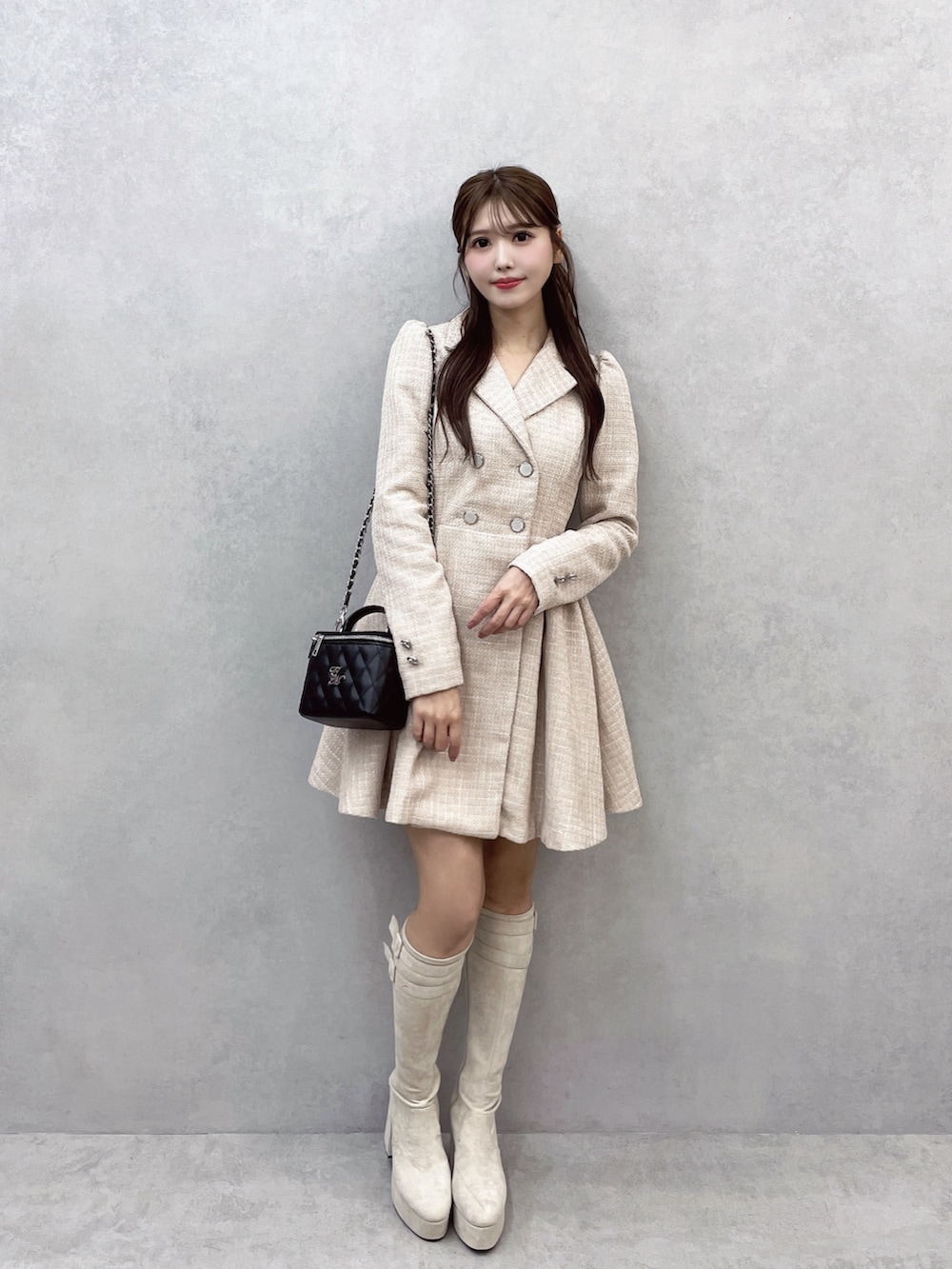 ピンク系のワンピース、ブラック系のハンドバッグ、ホワイト系のブーツを着用したレディースの秋コーディネートの3枚目の写真