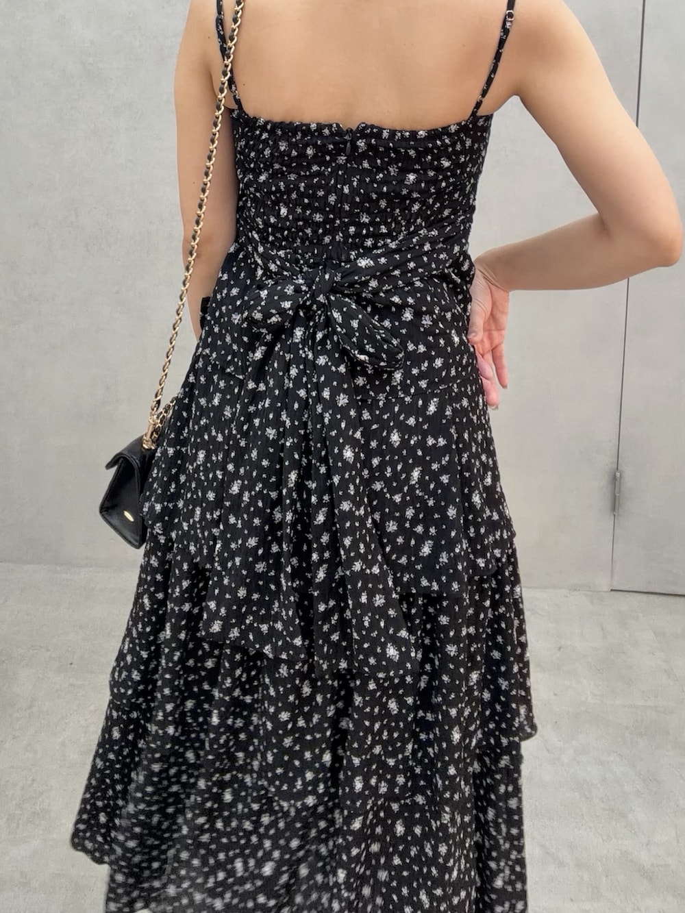 ホワイト系のサンダル、ブラック系のワンピース、ブラック系のハンドバッグを着用したレディースの冬コーディネートの6枚目の写真