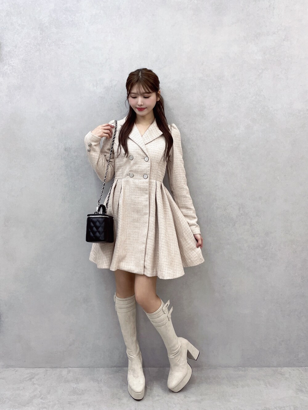 ピンク系のワンピース、ブラック系のハンドバッグ、ホワイト系のブーツを着用したレディースの秋コーディネートの2枚目の写真