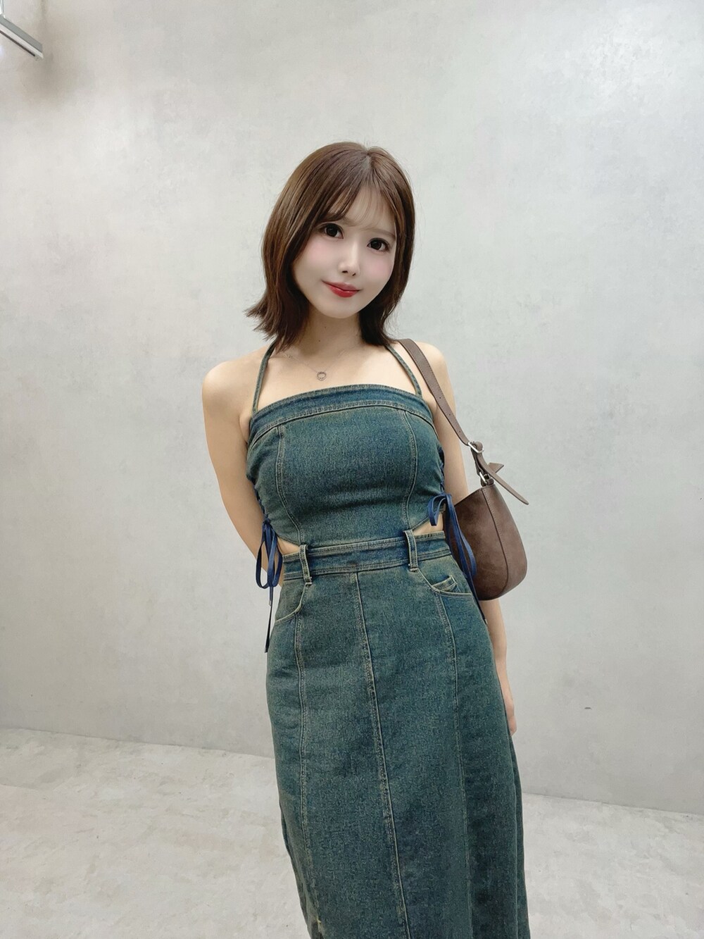 ブルー系のワンピース、ブラウン系のショルダーバッグ、ブラック系のサンダルを着用したレディースの秋コーディネートの4枚目の写真