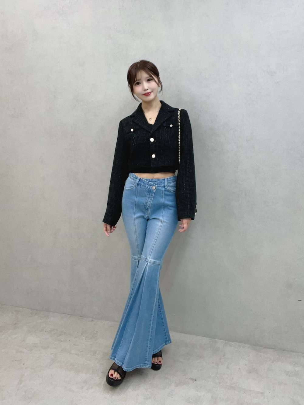 ブルー系のデニムパンツ、ブラック系のサンダル、ブラック系のテーラードジャケットを着用したレディースの秋コーディネートの3枚目の写真
