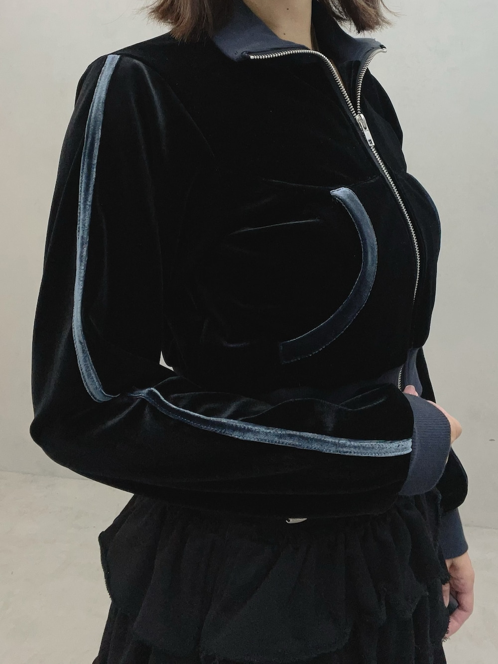 ブラック系のブルゾン、ブラック系のスカート、ホワイト系のスニーカーを着用したレディースの秋コーディネートの7枚目の写真