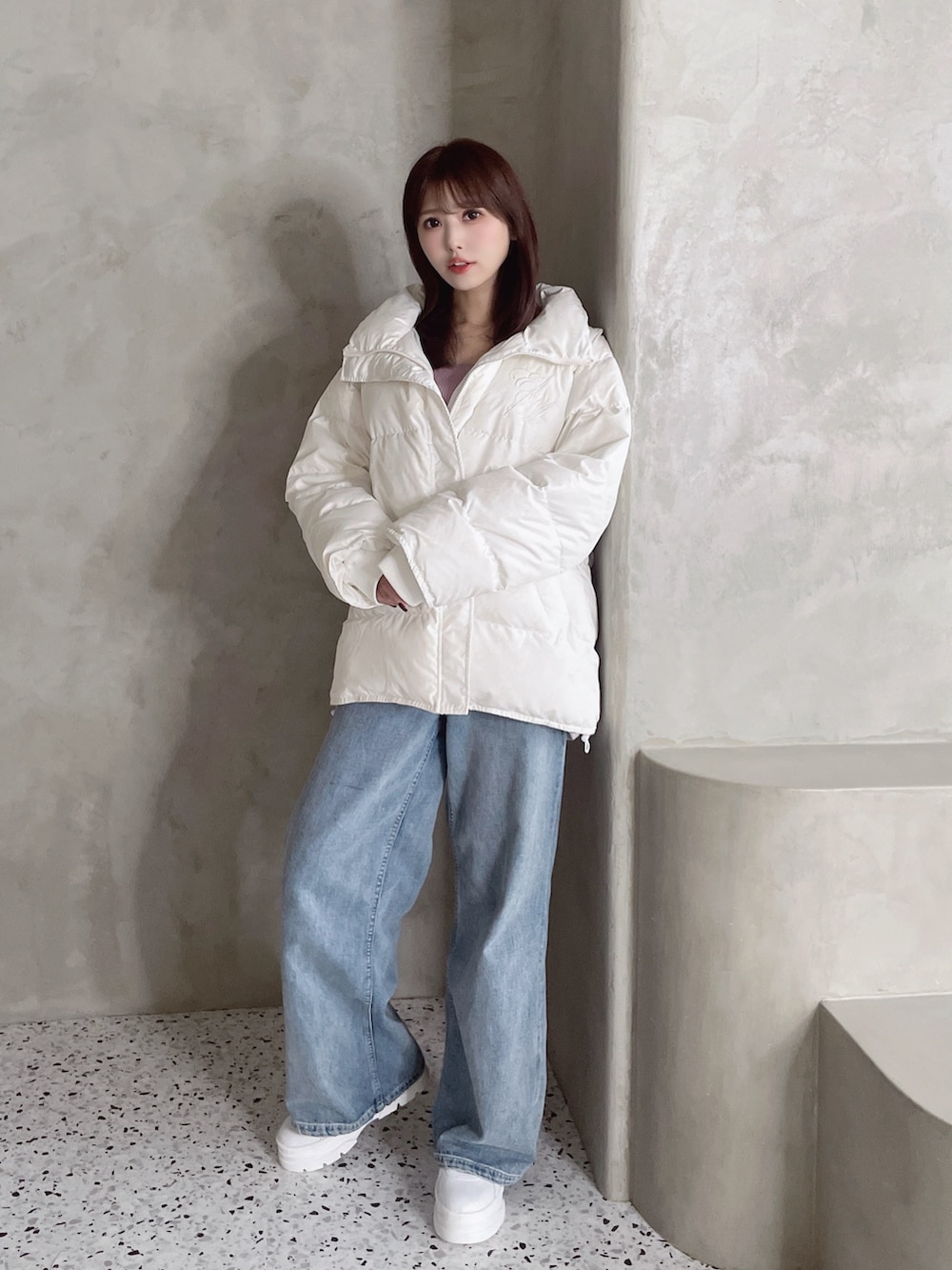 ホワイト系のダウンジャケット/コート、ブルー系のデニムパンツ、ホワイト系のスニーカーを着用したレディースの秋コーディネートの7枚目の写真