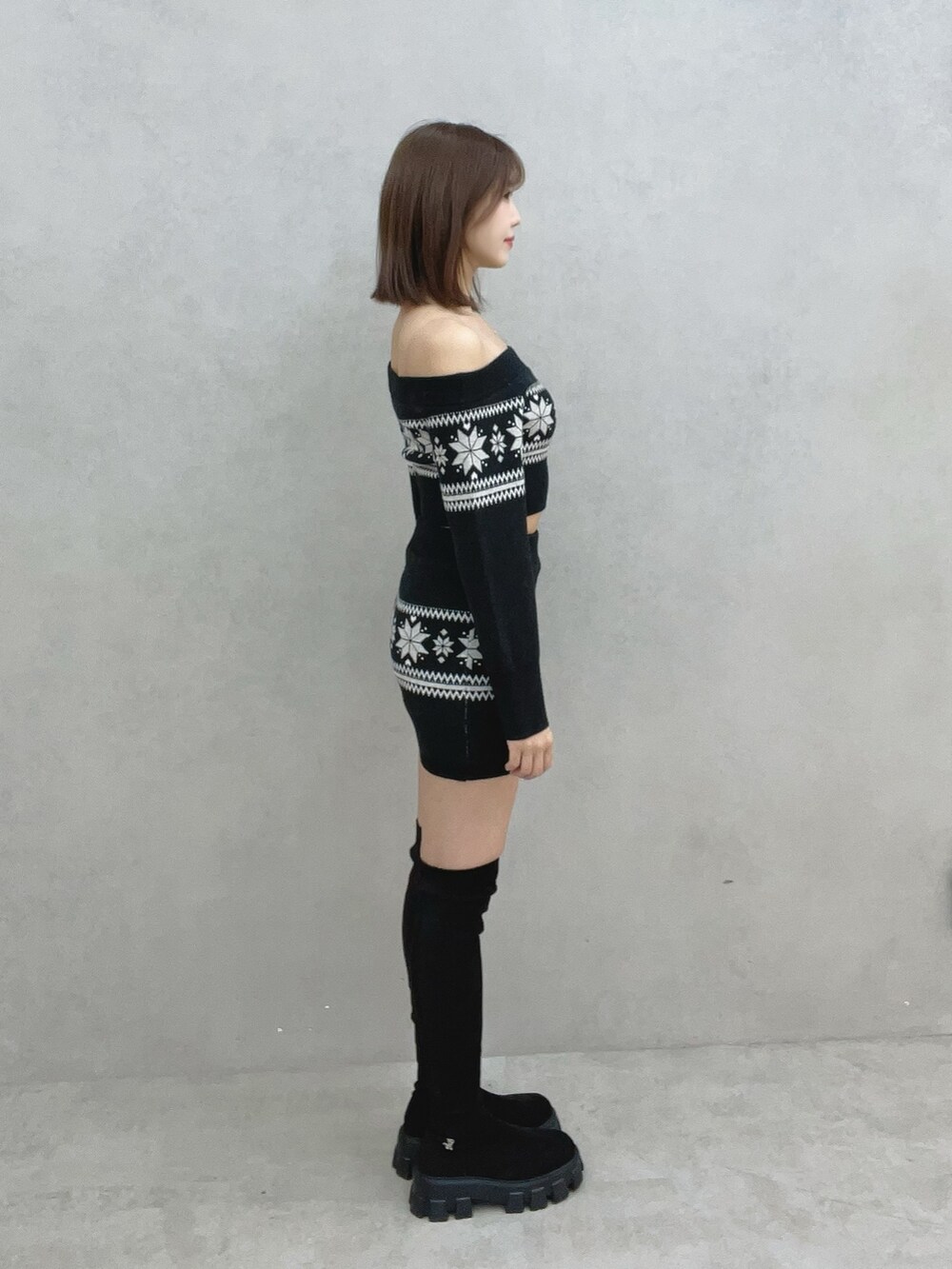 ブラック系のニット/セーター、ブラック系のスカート、ブラック系のブーツを着用したレディースの秋コーディネートの6枚目の写真