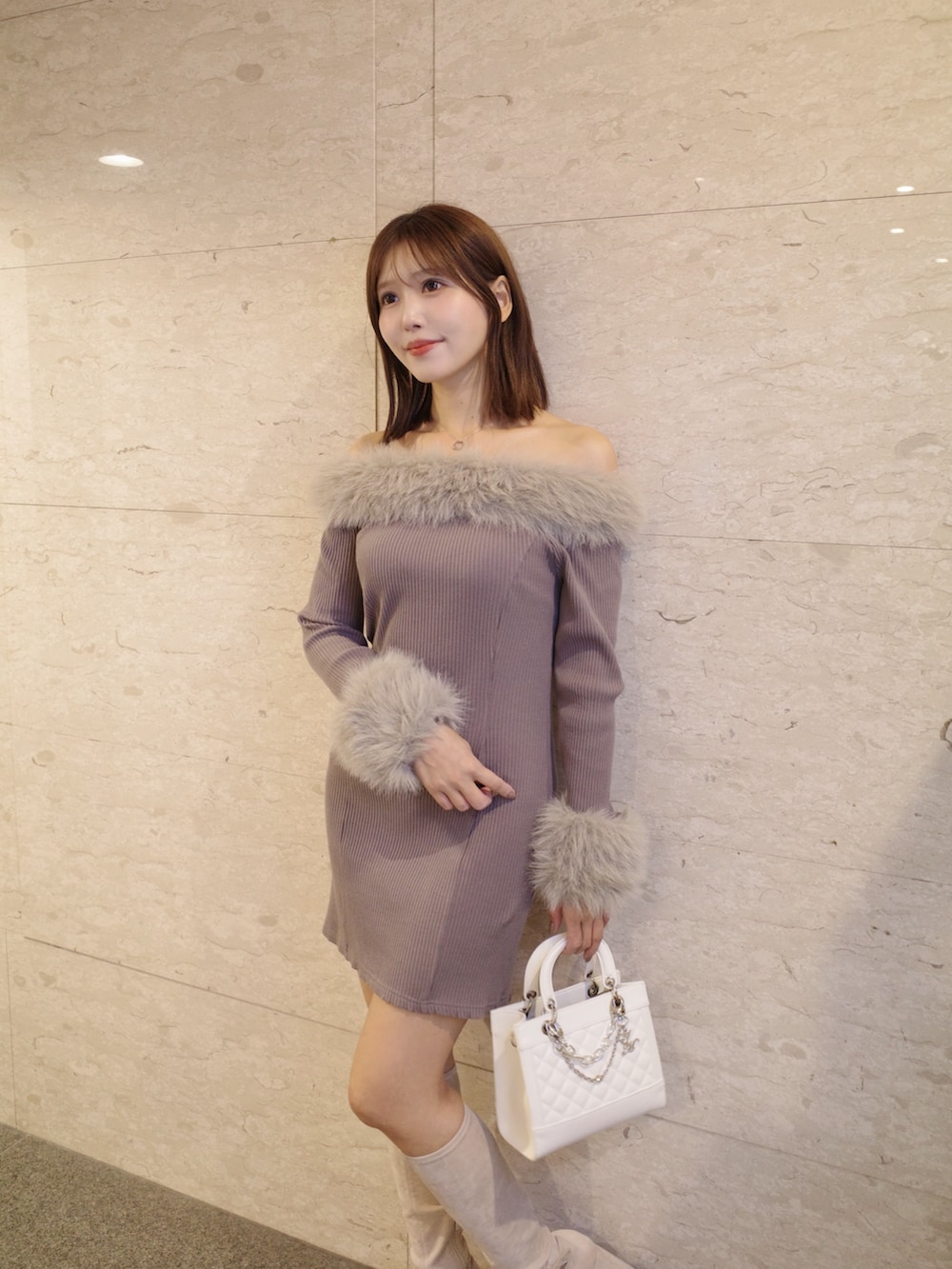 ブラウン系のワンピース、ホワイト系のハンドバッグ、ホワイト系のブーツを着用したレディースの秋コーディネートの2枚目の写真