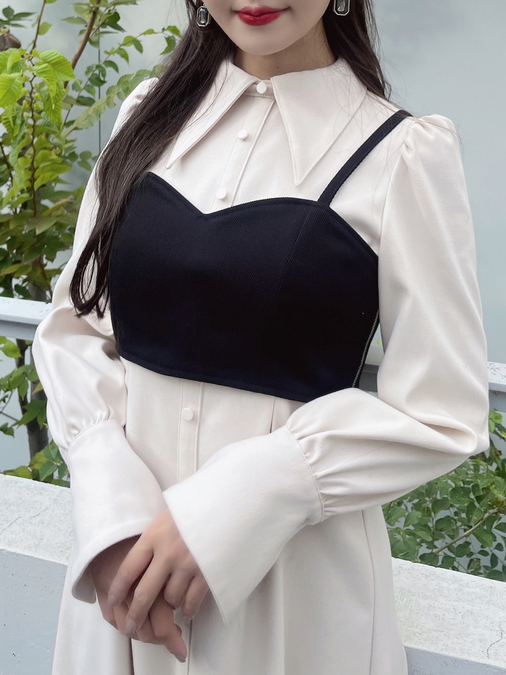 ホワイト系のワンピース、ブラック系のパンプス、ブラック系のピアス（両耳用）を着用したレディースの秋コーディネートの8枚目の写真