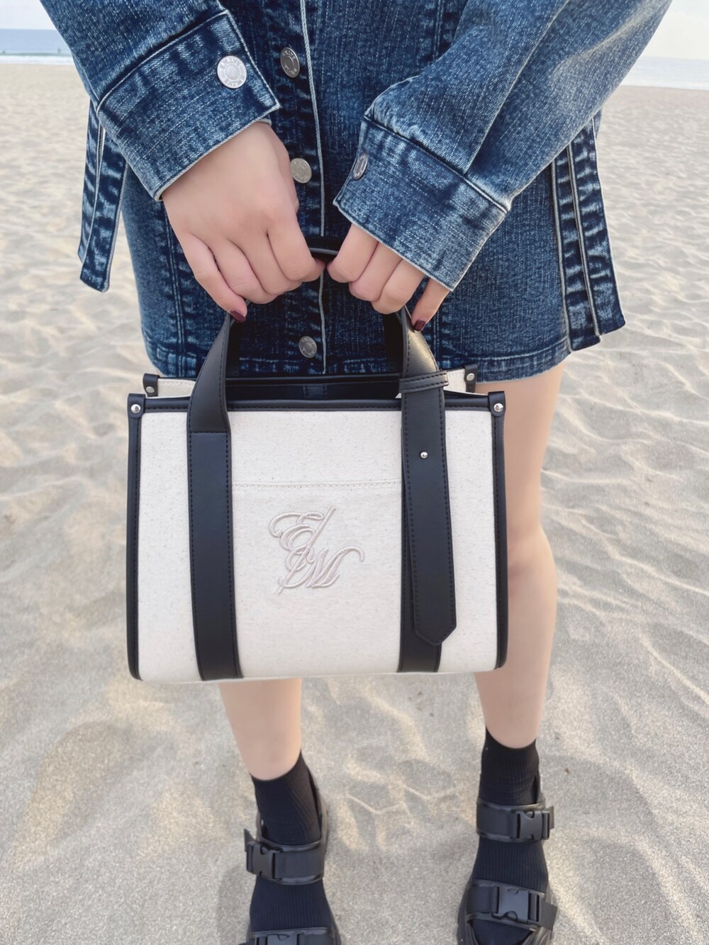 ブルー系のデニムジャケット、ブルー系のデニムスカート、ホワイト系のショルダーバッグを着用したレディースの冬コーディネートの6枚目の写真