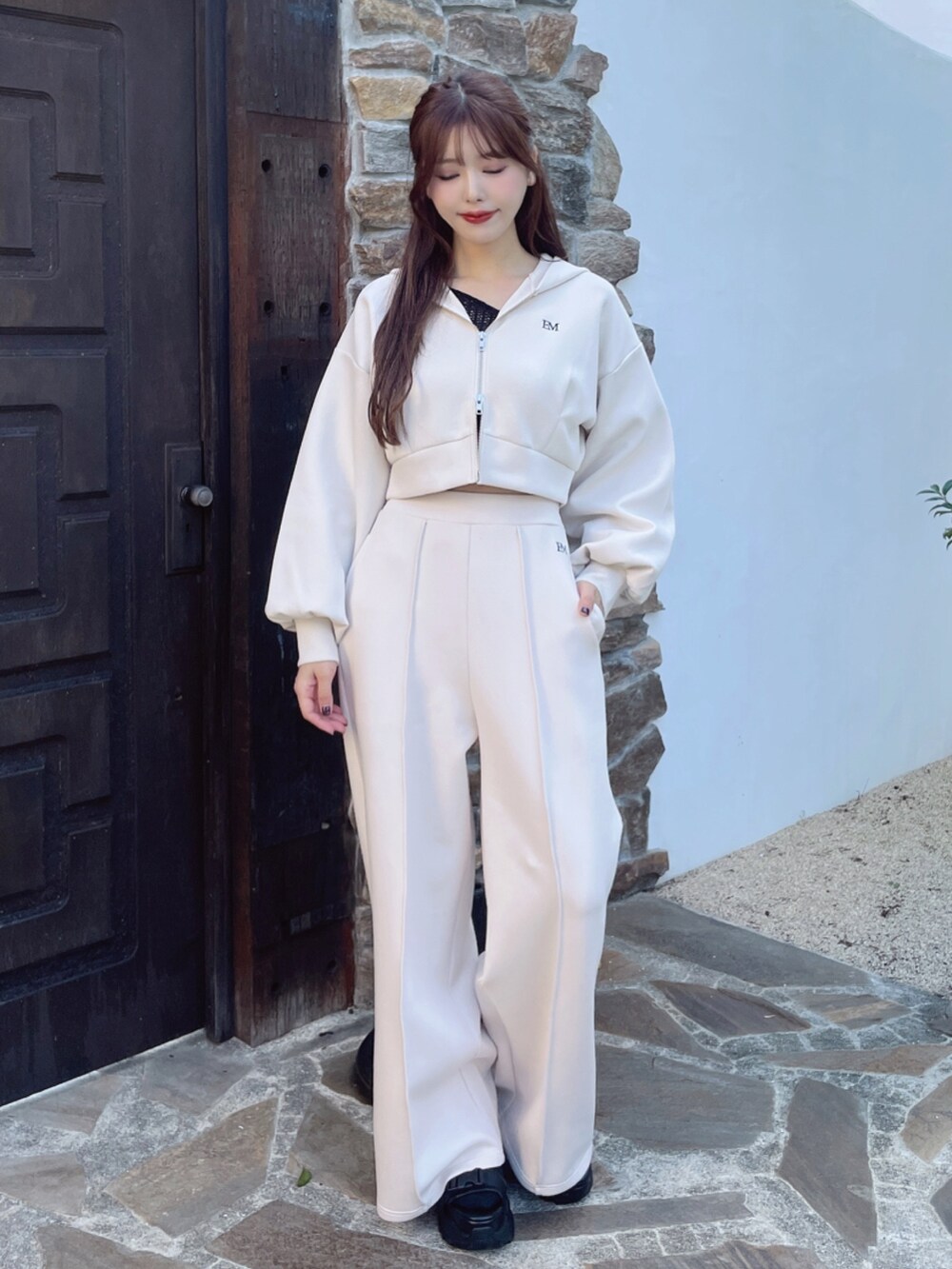 ホワイト系のパーカー、ホワイト系のその他パンツ、ブラック系のサンダルを着用したレディースの冬コーディネートの2枚目の写真