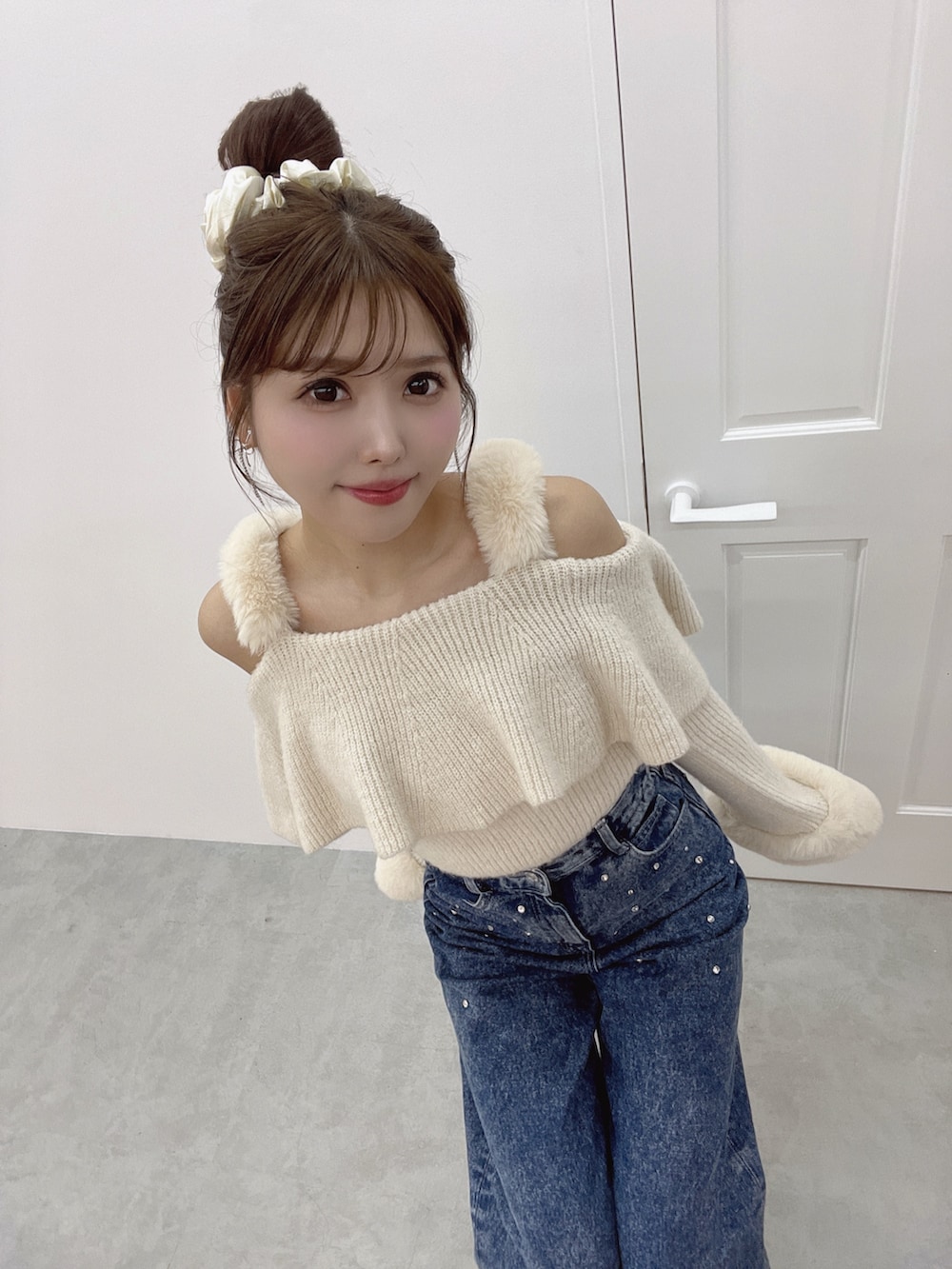 ホワイト系のニット/セーター、ブルー系のデニムパンツ、ホワイト系のパンプスを着用したレディースの秋コーディネートの3枚目の写真