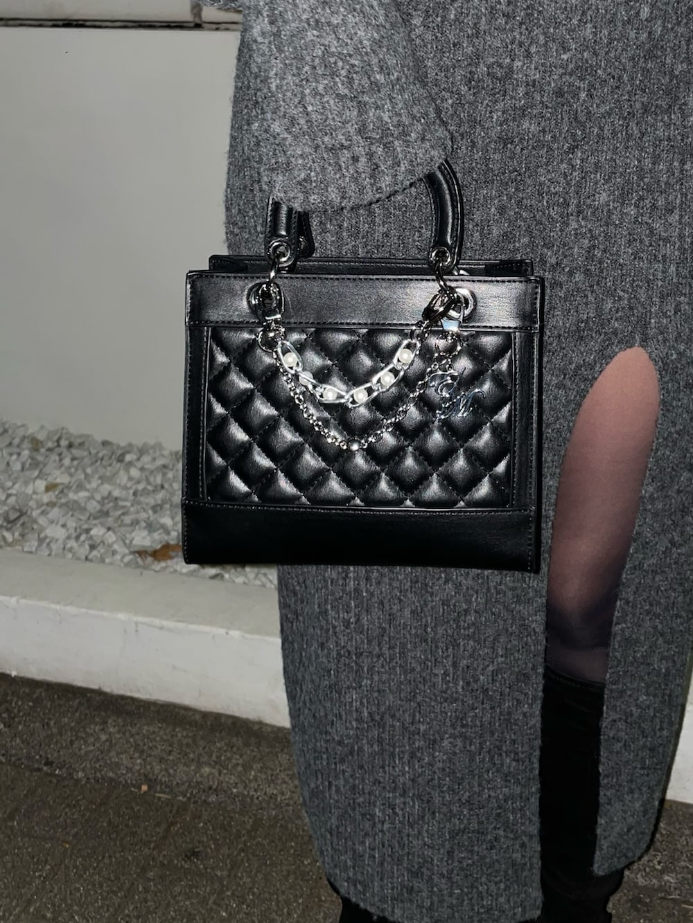 グレー系のワンピース、ブラック系のハンドバッグ、ブラック系のブーツを着用したレディースの冬コーディネートの10枚目の写真