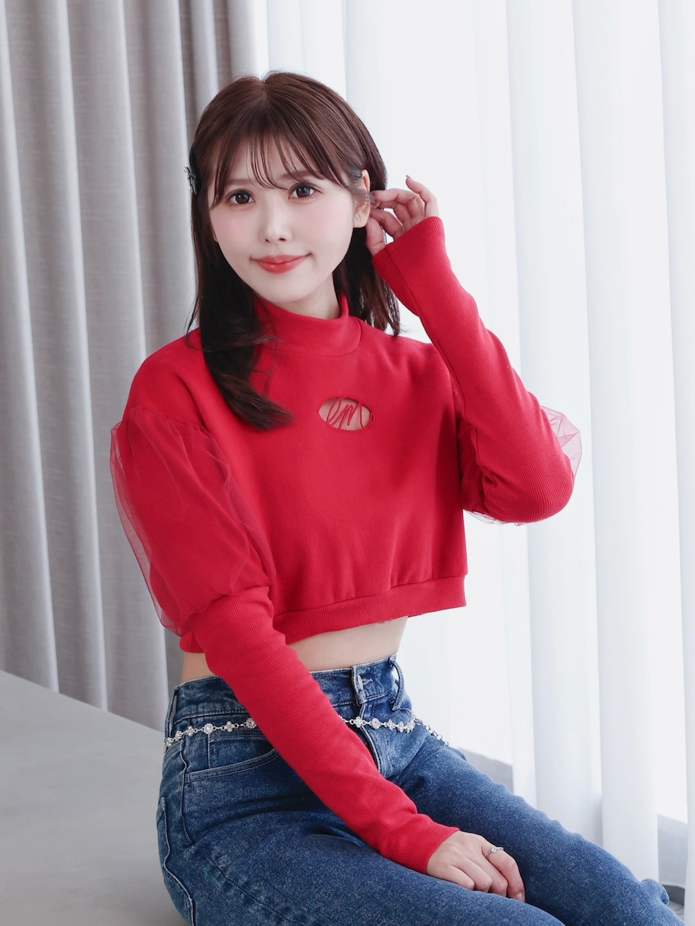 レッド系のスウェット、ブルー系のデニムパンツ、ブラック系のパンプスを着用したレディースの秋コーディネートの3枚目の写真