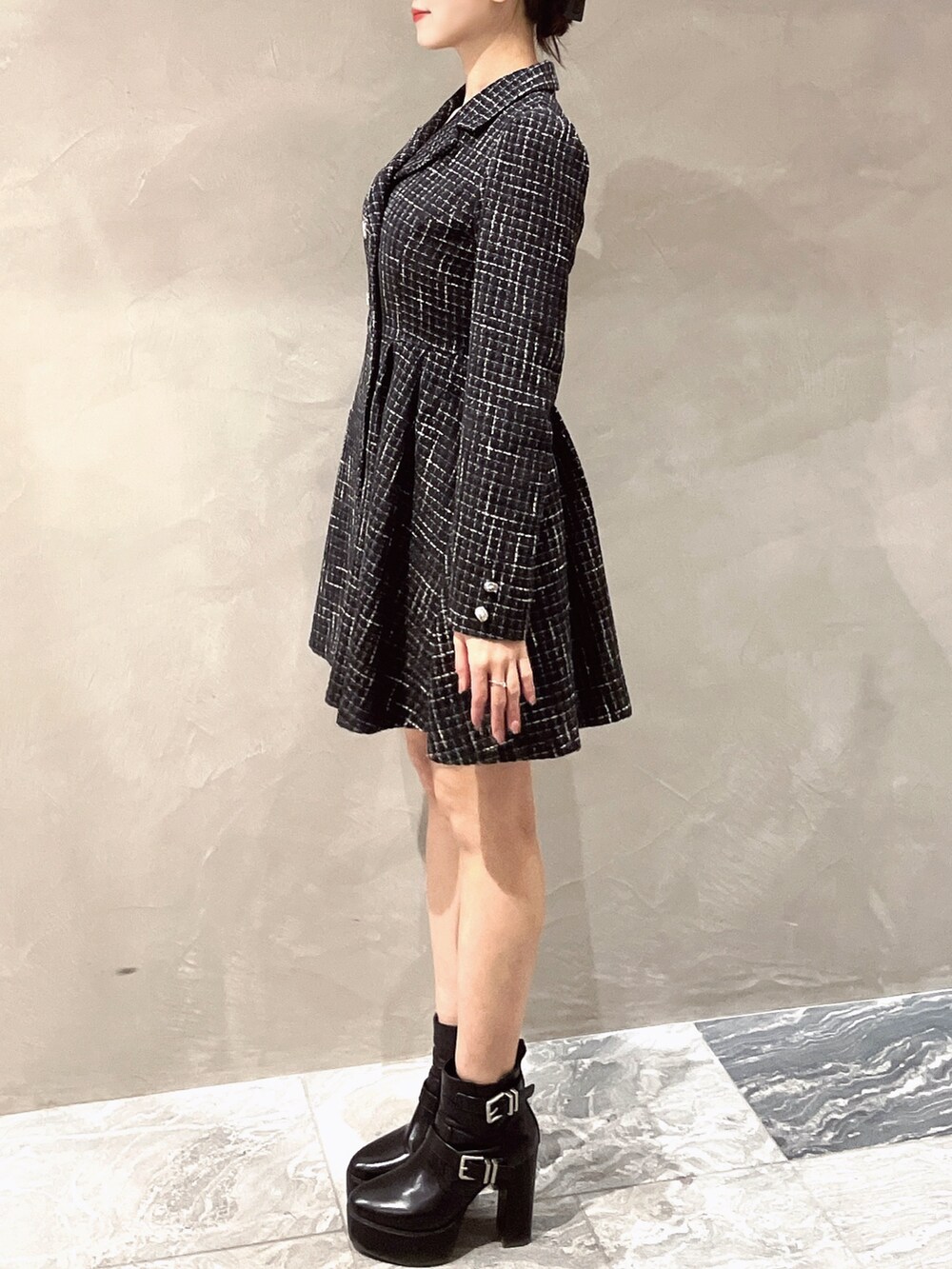 ブラック系のワンピース、ブラック系のブーツを着用したレディースの冬コーディネートの4枚目の写真