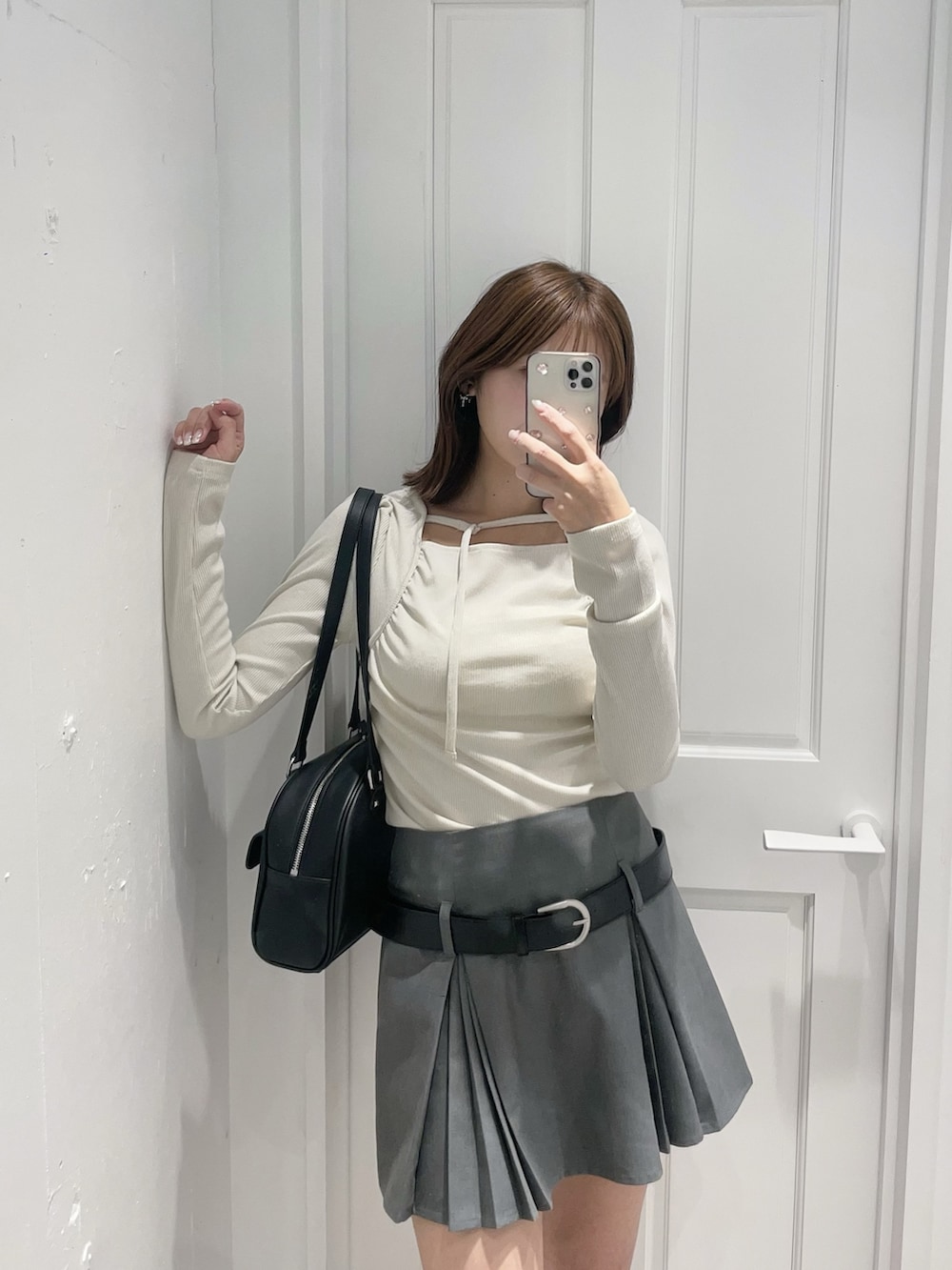 ホワイト系のTシャツ/カットソー、グレー系のスカート、ブラック系のボストンバッグを着用したレディースの春コーディネートの3枚目の写真