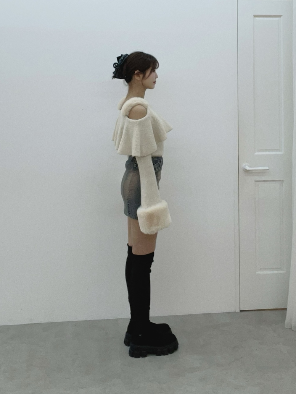 ホワイト系のニット/セーター、ブルー系のデニムスカート、ブラック系のブーツを着用したレディースの秋コーディネートの5枚目の写真